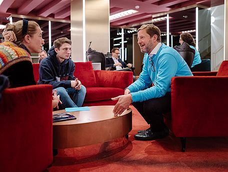 Mitarbeiter und Mitarbeiterinnen unterhalten sich mit Besuchern des Nationaltheaters
