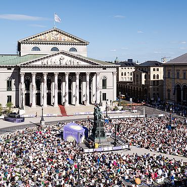 Die Leinwand vor dem Nationaltheater und die Zuschauer auf dem Max-Joseph-Platz aufgenommen aus der Ferne