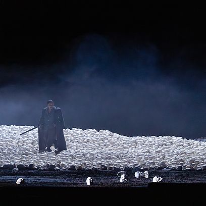 Szene Macbeth: Ein Mann steht in einem Meer an Totenk&ouml;pfen