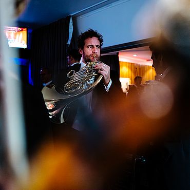 Musiker mir Horn hinter der Bühne in London