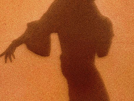 [Translate to EN:] Schatten einer Frau vor orangenem Hintergund