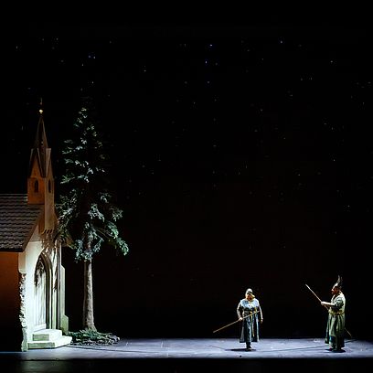 Br&uuml;nnhilde and Wotan in front of a chapel.