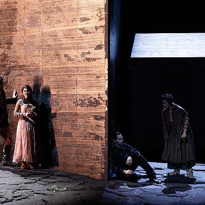 Szenenbild Faust: Marguerite und Faust unterhalten sich, M&eacute;phistoph&eacute;l&egrave;s h&ouml;rt zu