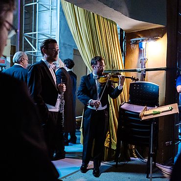 Musiker:innen des Orchesters hinter der Bühne in Bukarest