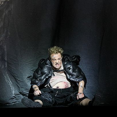 Szene Parsifal: Ein zerzauster Mann sitzt auf dem Boden