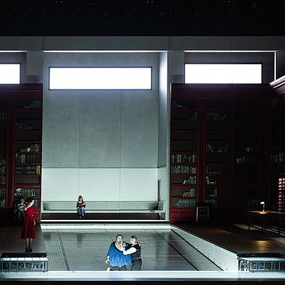 Szenenbild Salome: Eine Bibliothek, viele B&uuml;cher sind in den Regalen umgefallen; Salome und Jochanaan im Zentrum der B&uuml;hne