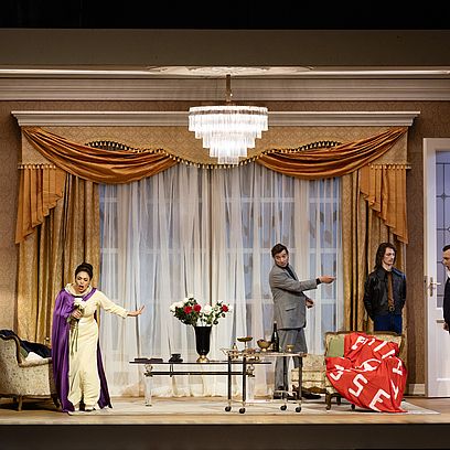 Szene aus Tosca: Eine Wohnung auf der B&uuml;hne, vier Menschen im Wohnzimmer 