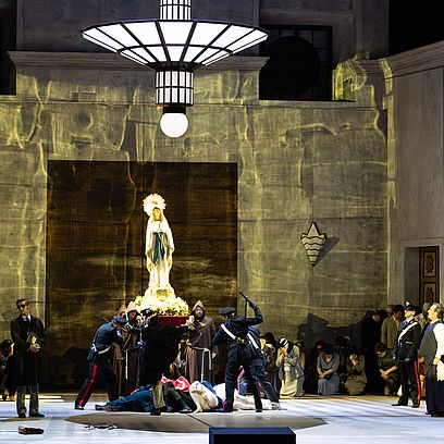 Szene aus Tosca: Die Polizei verhaftet einen Mann vor einer Modonnenstatue
