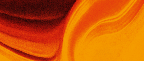 Abstract background: softly flowing fabric in vivid orange, red and yellow tones with gentle folds and a fine grain.