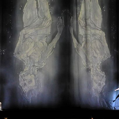 Szene Parsifal: Ein und eine Frau vor Lichtprojektionen