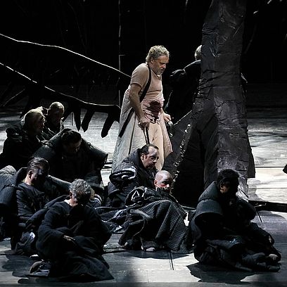 Szene Parsifal: M&auml;nner in einem Wald aus schwarzen B&auml;umen