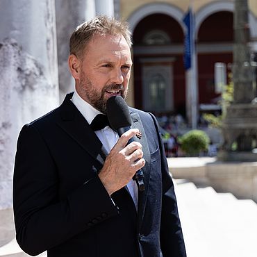 Steven G&auml;tjen moderiert den Livestream auf den Stufen des Nationaltheaters